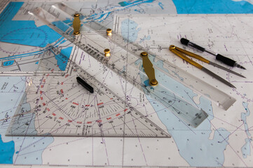 Maps of the ship for plotting. Plotter, divider, ruler and pen. Close-up.