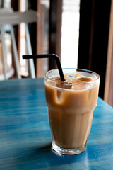 カフェの青いテーブルの上のアイスコーヒー