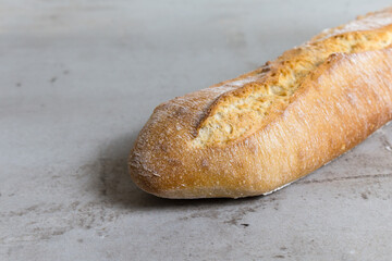 close up testy baguette, baked bread on grey stone table background. French bread. View with copy space