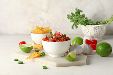 Bowl of tasty Pico de Gallo salsa and nachos on table - obrazy, fototapety, plakaty