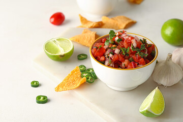 Bowl of tasty Pico de Gallo salsa and nachos on table