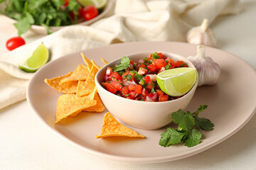 Bowl of tasty Pico de Gallo salsa and nachos on table