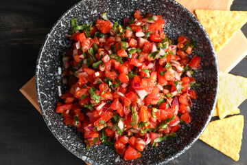 Bowl of tasty Pico de Gallo salsa on table