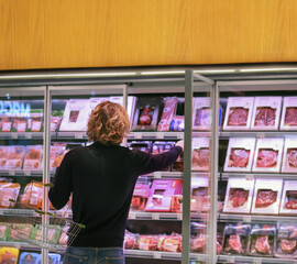 man purchasing a packet of meat at the supermarket.
