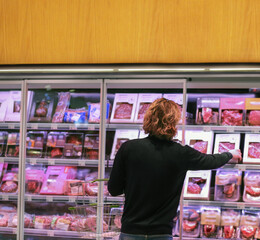 man purchasing a packet of meat at the supermarket.