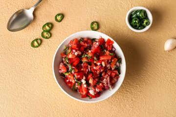 Bowl of tasty Pico de Gallo salsa on color background