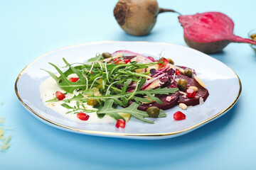 Plate with delicious beetroot carpaccio on color background