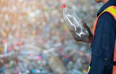 Close up hand holding plastic bottle and recycle waste separation in recyclable waste factory
