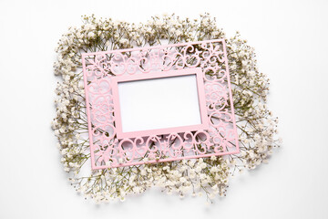 Blank frame and beautiful gypsophila flowers on white background