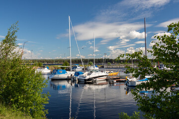 Fototapeta na wymiar boats and sailboats in a small lakeshore marina in the countryside