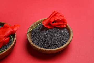 Bowls with poppy seeds and flowers on color background
