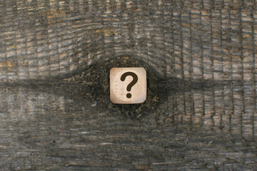 a question mark on the wooden cubes on a wooden backgroundbackground . FAQ frequency asked...