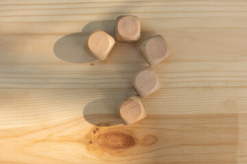 Question mark made of wooden cubes on a wooden background. FAQ frequency asked questions, Answer, Brainstorming Concepts