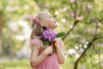 Obraz premium Portrait of a little girl with a rhododendron