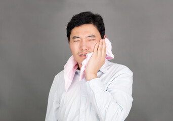 Man with toothache puts a towel on his fa