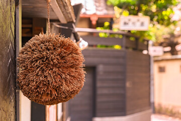 Close up on a Sugidama ball made of dried Japanese cedar or redwood symbol of new sake draw hung by brewer at the entrance of a traditional kaiseki restaurant in a narrow path of Kagurazaka district.