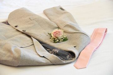 Gray blazer with boutonniere and a tie - groom outfit