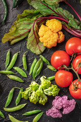 Raw organic vegetables, shot from above on a dark background. Healthy vegan diet ingredients