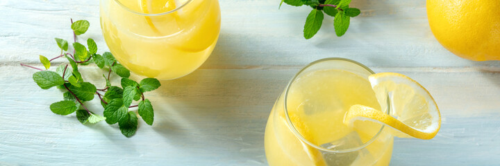 Fresh lemon drink panorama. Homemade lemonade panoramic banner. Refreshing citrus drink with mint on a wooden background