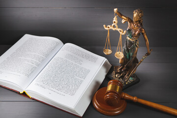 statue of justice, book and gavel on wooden table