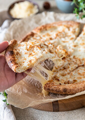 Homemade delicious hot pizza with chicken and slice with melting stretching cheese. Close up.