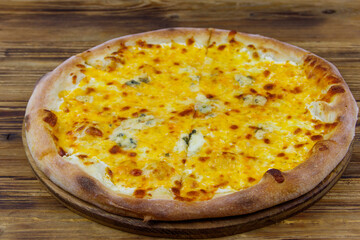 Pizza Four cheese on a wooden background