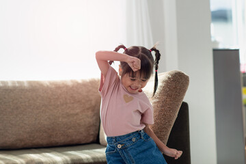 Happy Asian child having fun and dancing in a room