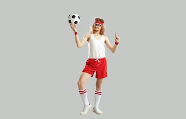 Full body funny man holding soccer ball. Full length happy smiling male football nerd in glasses,...