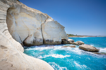 Rosh HaNikra Grottoos on sunny day with blue sea background. Natural sea caves on the border with Lebanon and Israel