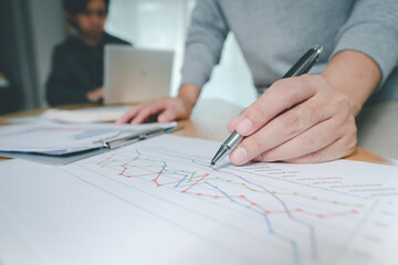 Hand of businessman point to graph. is discussing together in conference room talk about Report, Sales, Target, Marketing,