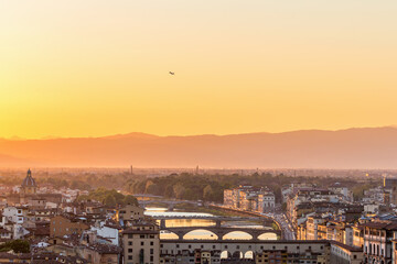 Sunset view of Florence in Italy with a airliner that lifts