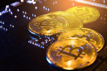 pile of bitcoins on computer mainboard. concept of crypto currency investment. closeup.