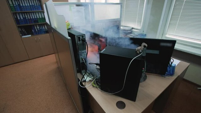Smoke from computer inside office before fire of electronics. Electrical wiring short circuit. Electrical overload. Violation of security rules. Danger to life and health. Safety, caution. Alarm