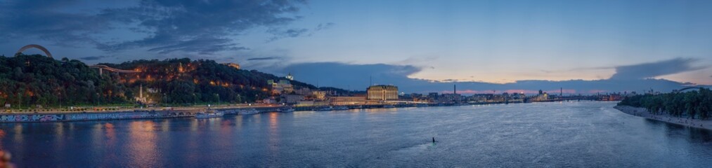 Night panorama of Kiev, where you can see the Dnieper River, the embankment, Pochtovaya Square, St. Andrew's Church, the People's Friendship Arch, Vladimirskaya Gorka.