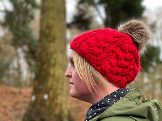 Side View Of A Woman Wearing A Knit Hat Walking In Woodlands