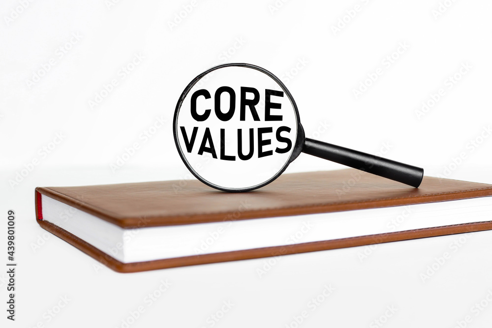 Poster core values. text on magnifier glass. magnifier on notepad on white background
