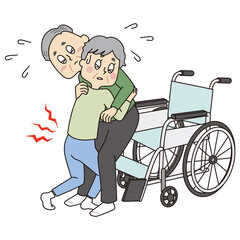 車椅子に夫をのせようと苦労をするシニア女性