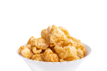 Close up of crispy pork rinds in a white bowl.