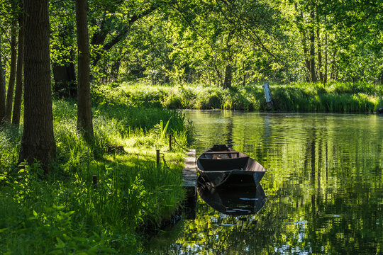 Water canal with old boat in the biosphere reserve Spree forest (Spreewald) in the state of Brandenburg, Germany, in springtime.