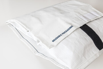 Reusable bag used by online shops for shipping. Postage for sending it back is paid by the shop. Concept for recycling and sustainability. White background.