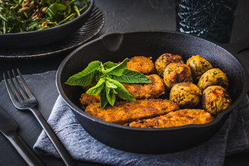Vegetarian nuggets and vegan balls in an iron pan on dark background, healthy food