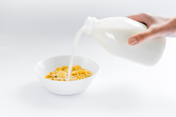 cornflakes with milk in a plate on a white background. dry quick breakfast. american food