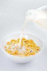 cornflakes with milk in a plate on a white background. dry quick breakfast. american food