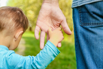 the parent holding the child's hand with a happy background