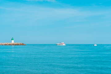 Obraz premium Sea view of the lighthouse and yacht port. Mediterranean sea of french riviera during sunrise. High quality photo
