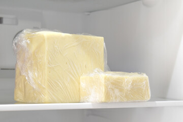 Cheese with plastic wrap in the fridge.  The concept of how to store cheese properly. 