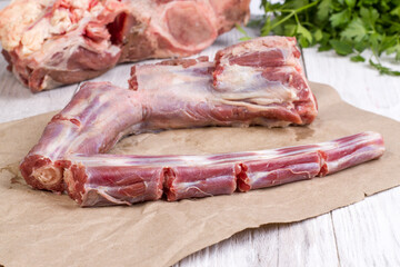 Chunks of fresh raw beef oxtail meat on a wooden background