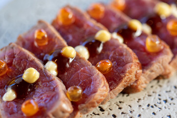 Macro detail of wagyu beef tataki morsel.