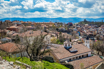 Fototapeta na wymiar Plovdiv, Bulgaria, elevated cityscape view from Nebet Tepe, one of the city famous hills. Lovely cloudy blue sky.