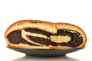 Two fragrant freshly baked poppy seed rolls on a black ceramic saucer, close-up, isolated on white.